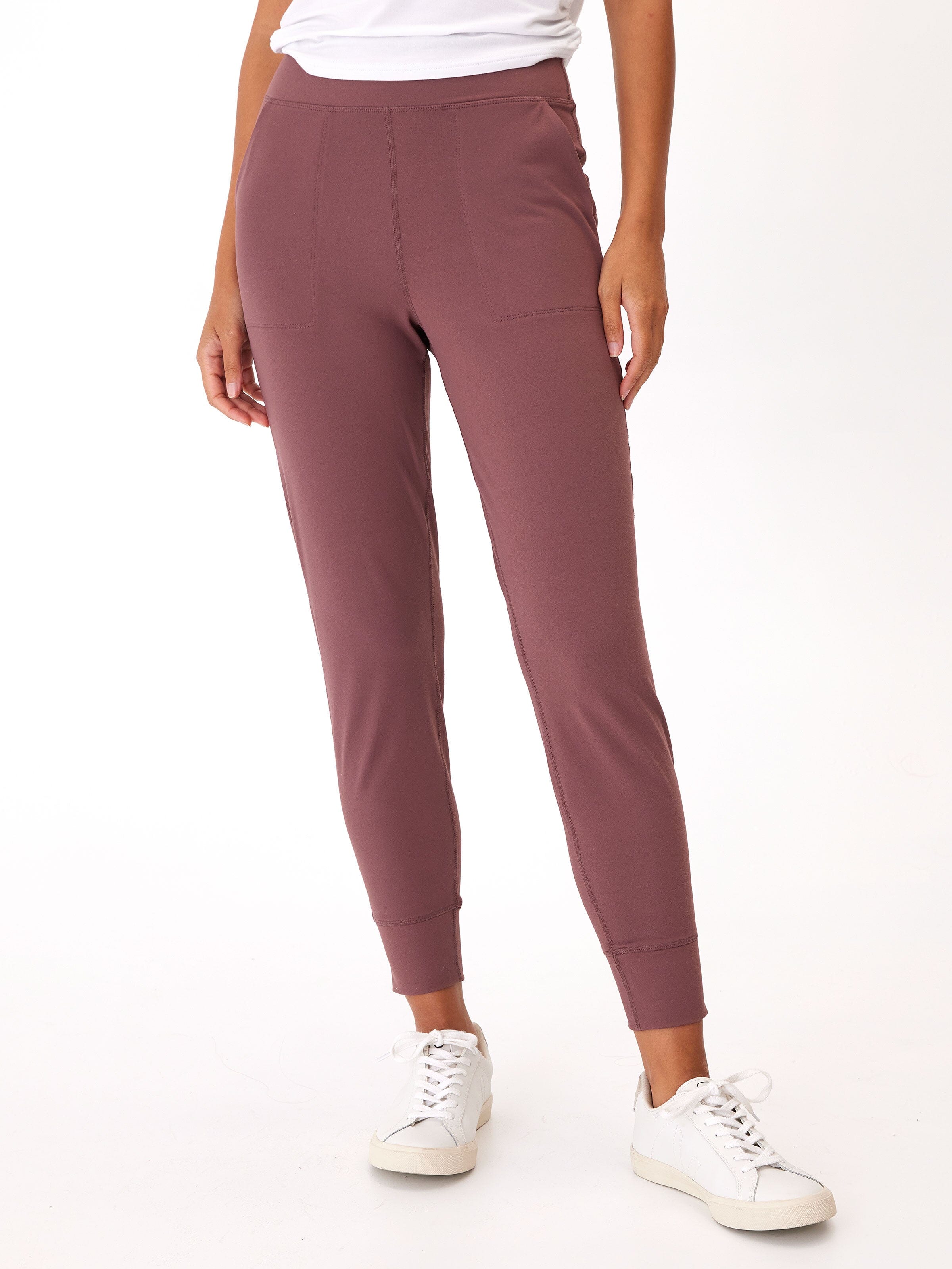 Woman wearing high-rise tapered Lydia Joggers in dusty rose, styled as athleisure.