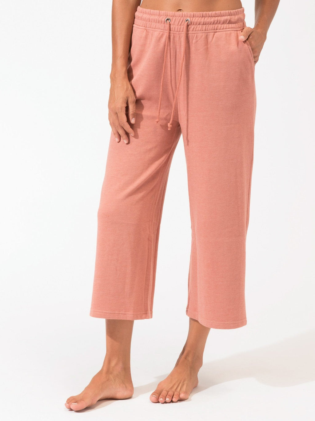 Woman wearing Haisley wide-leg knit crop pants in muted dusty rose in a minimalist setting