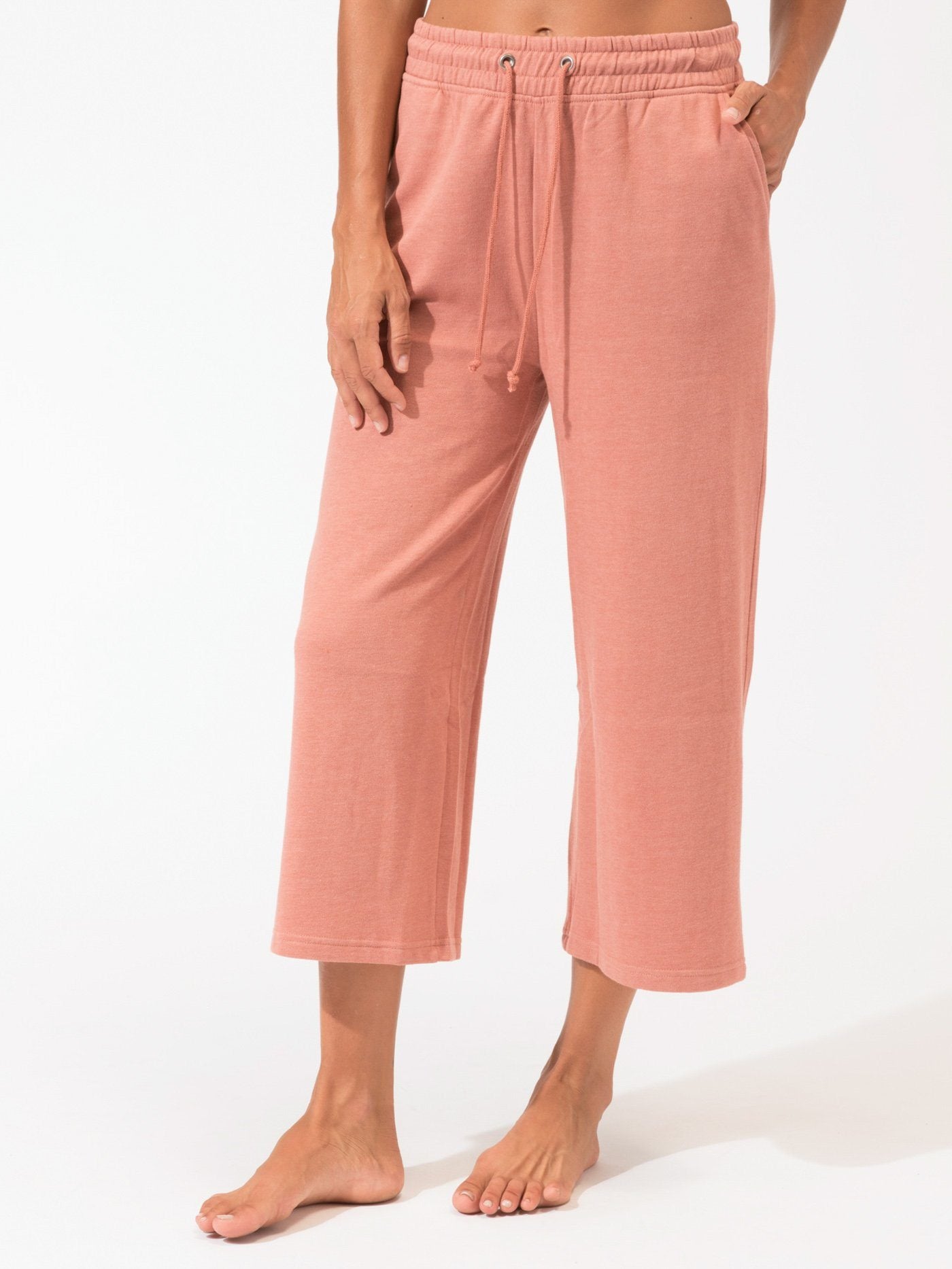 Woman wearing Haisley wide-leg knit crop pants in muted dusty rose in a minimalist setting