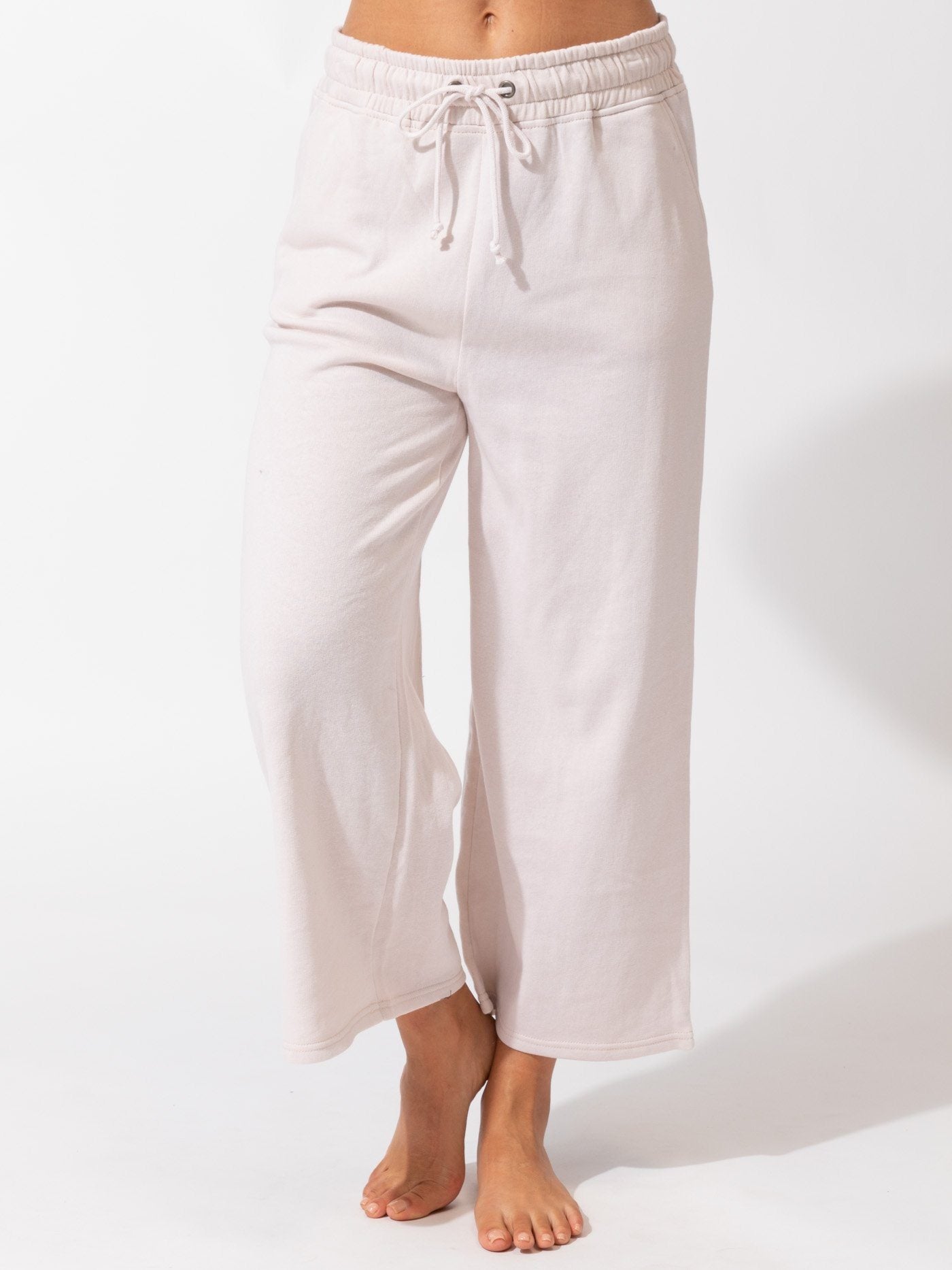 Model wearing pale pink wide-leg Haisley crop pants in a minimalist setting