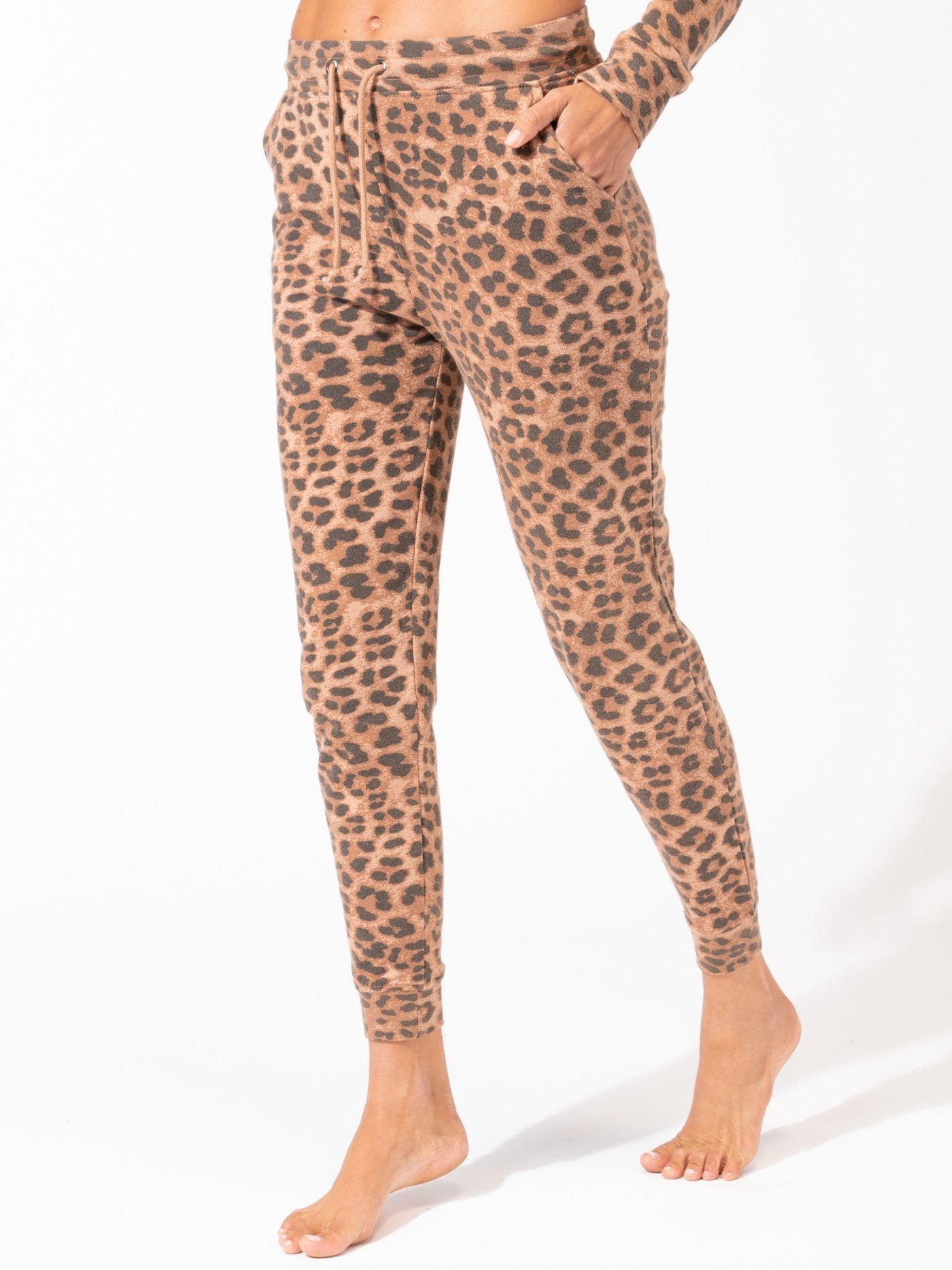 Women wearing Tanory Leopard Print Joggers in tan and brown knit fabric with a relaxed tapered fit.