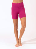 Woman wearing magenta high-rise Sylvana active shorts in a sporty, minimalist style.