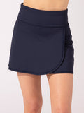 Woman wearing a solid navy blue Nani Performance Skort with built-in shorts and zipper pocket.