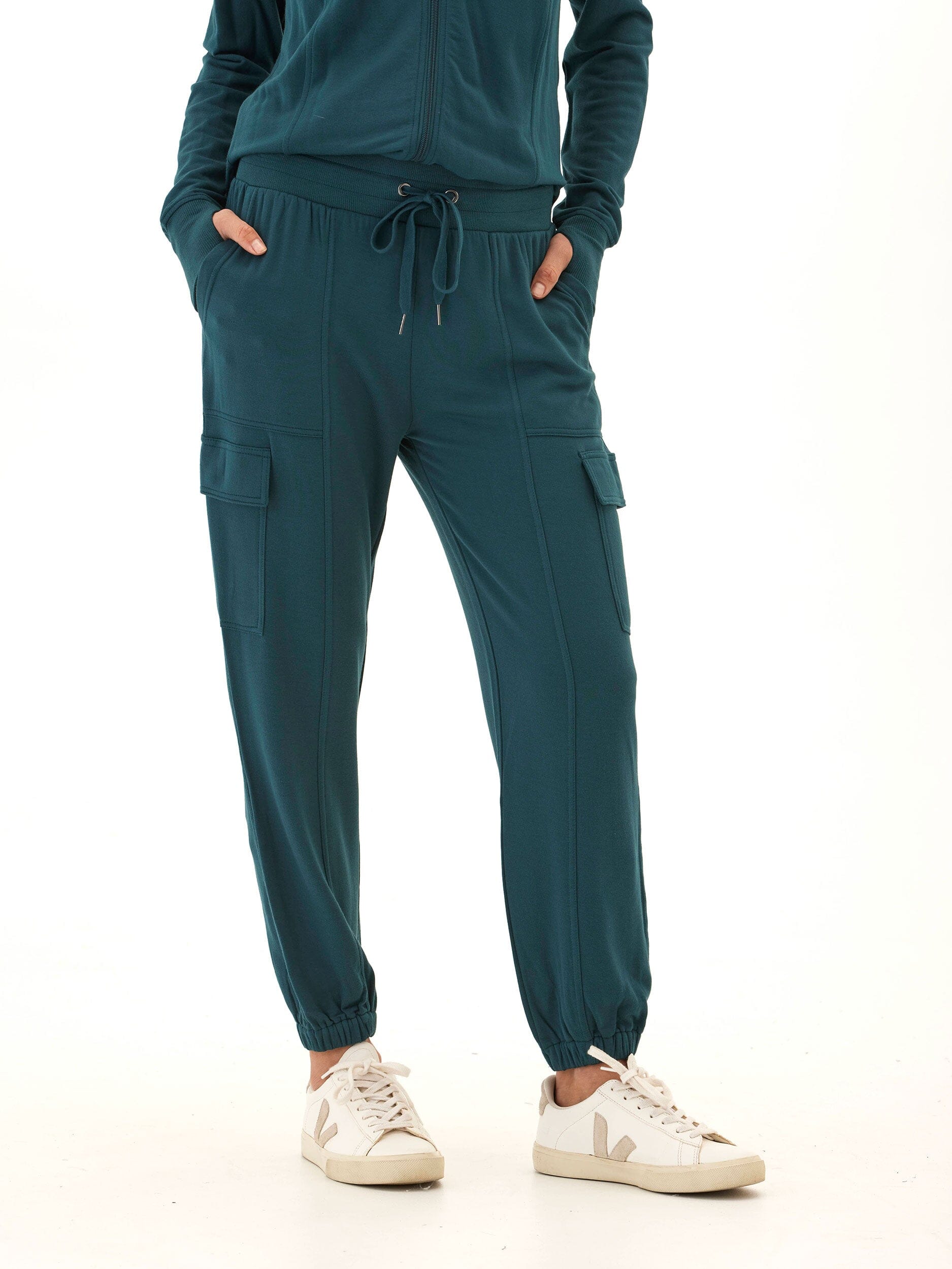 Woman wearing relaxed fit Margot Feather Fleece Cargo Joggers in deep teal knit fabric.