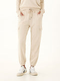 Woman wearing Margot Feather Fleece Cargo Joggers in beige with utility pockets.