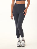 Woman wearing Elena High Rise 7/8 leggings in charcoal gray with side pocket details