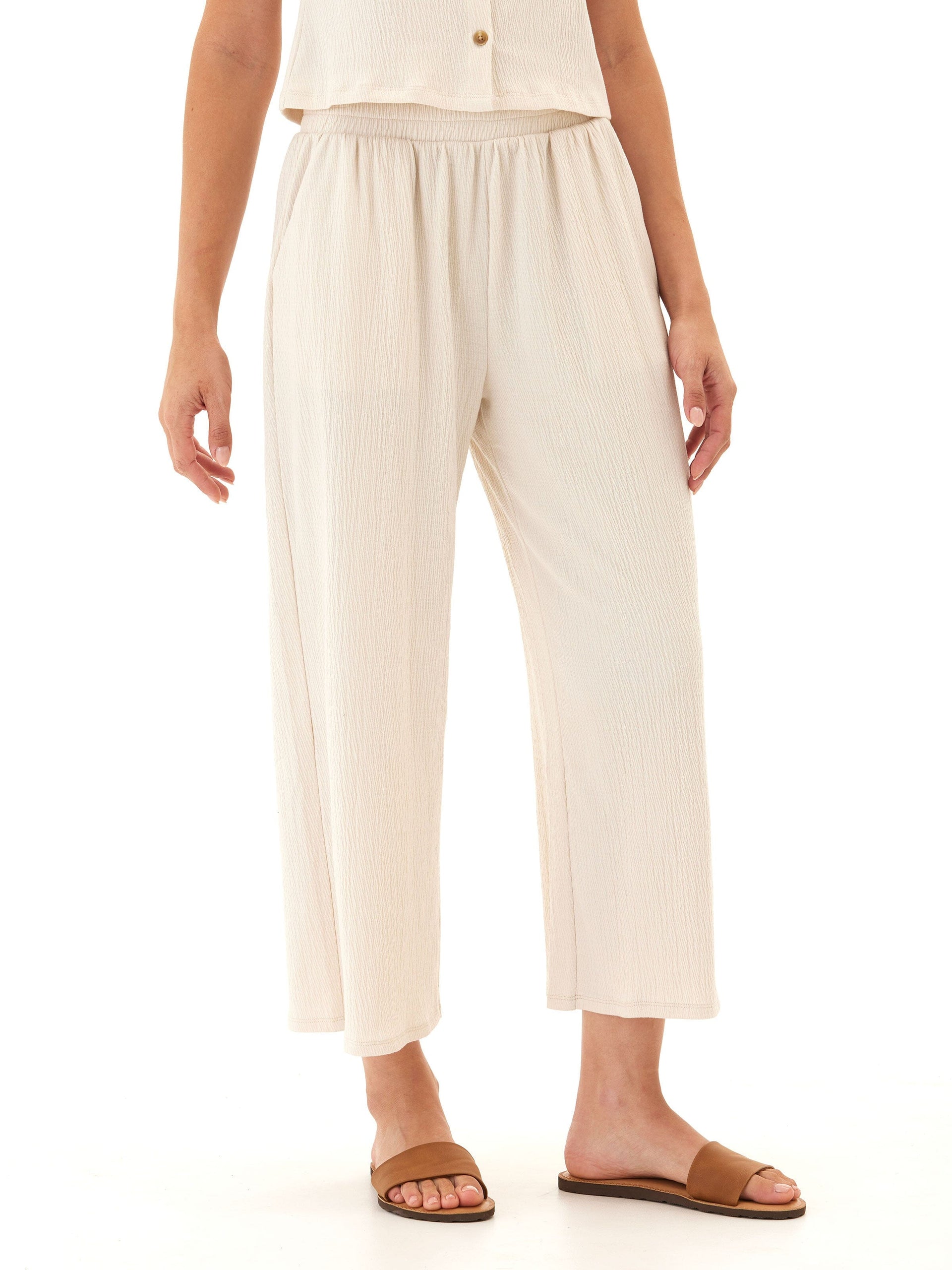 Woman wearing comfortable wide-leg jersey capri pants with smocked elastic waistband and side pockets