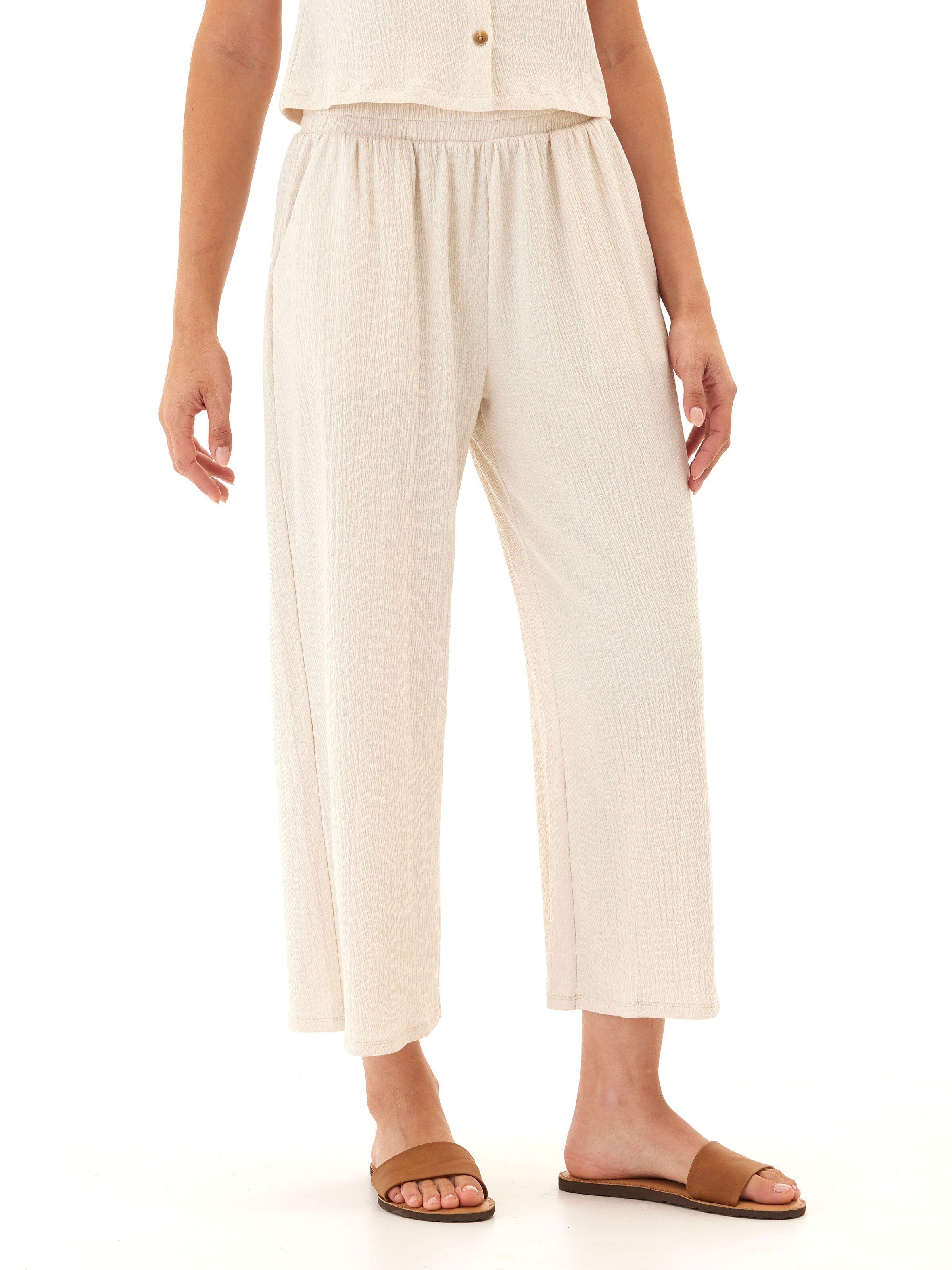 Woman wearing comfortable wide-leg jersey capri pants with smocked elastic waistband and side pockets