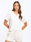 Woman wearing a relaxed-fit off-white towel terry polo with cuffed sleeves