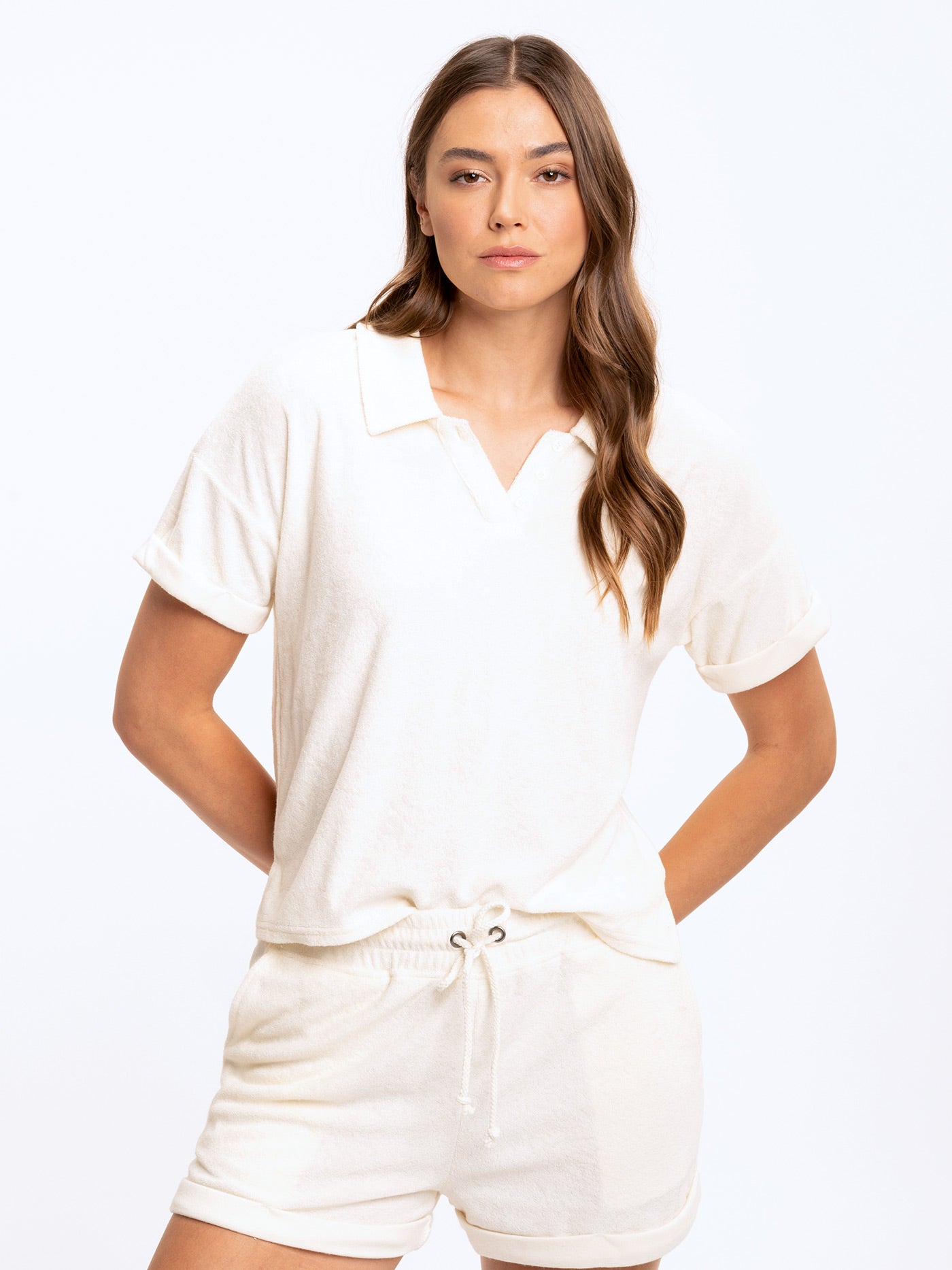 Woman wearing a relaxed-fit off-white towel terry polo with cuffed sleeves