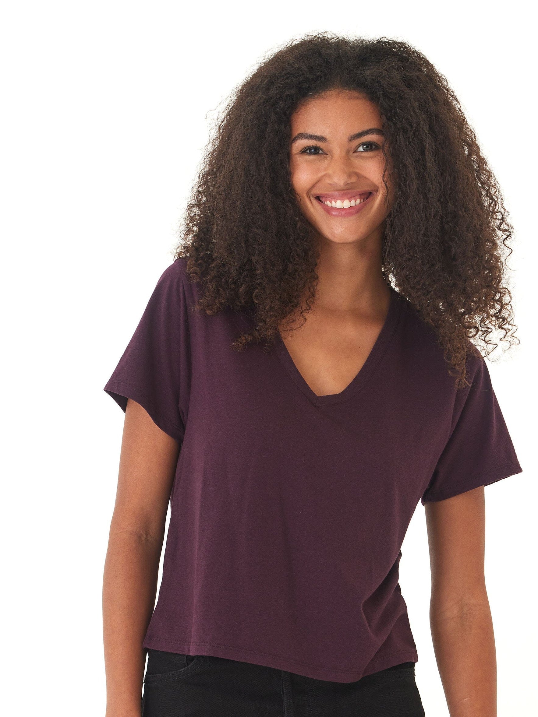 Women wearing a minimalist dark purple Core Triblend Jersey V-Neck Tee with a relaxed knit fit.
