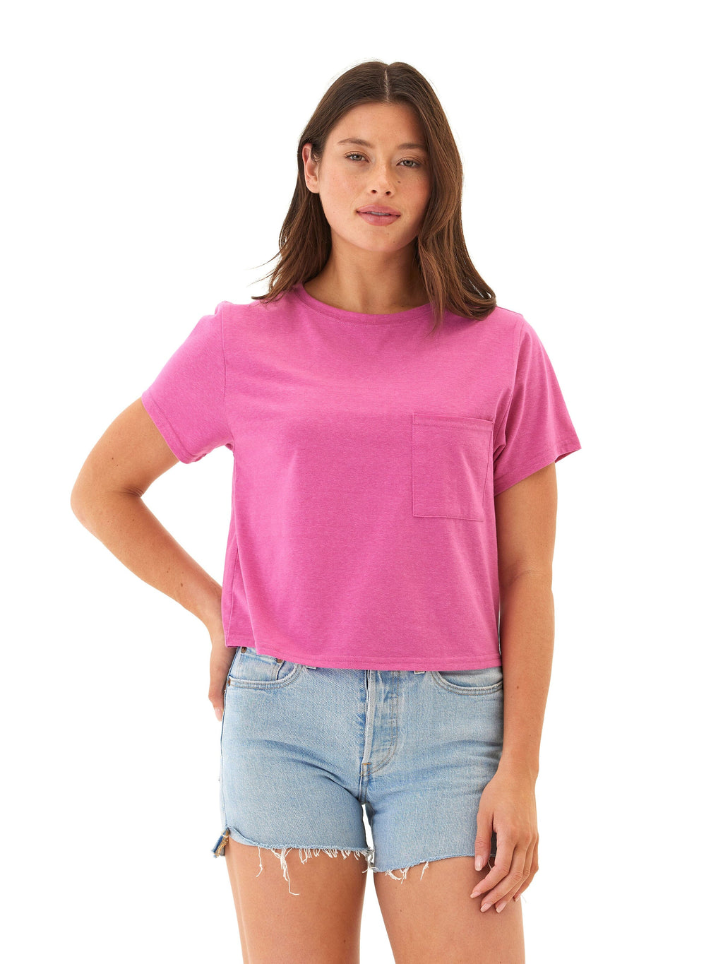 A woman wearing a vibrant magenta pink relaxed-fit short-sleeve jersey pocket tee with a crew neckline.