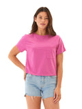 A woman wearing a vibrant magenta pink relaxed-fit short-sleeve jersey pocket tee with a crew neckline.