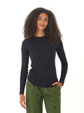 Woman wearing a black Torri Feather Rib long sleeve crew neck tee with a curved hem