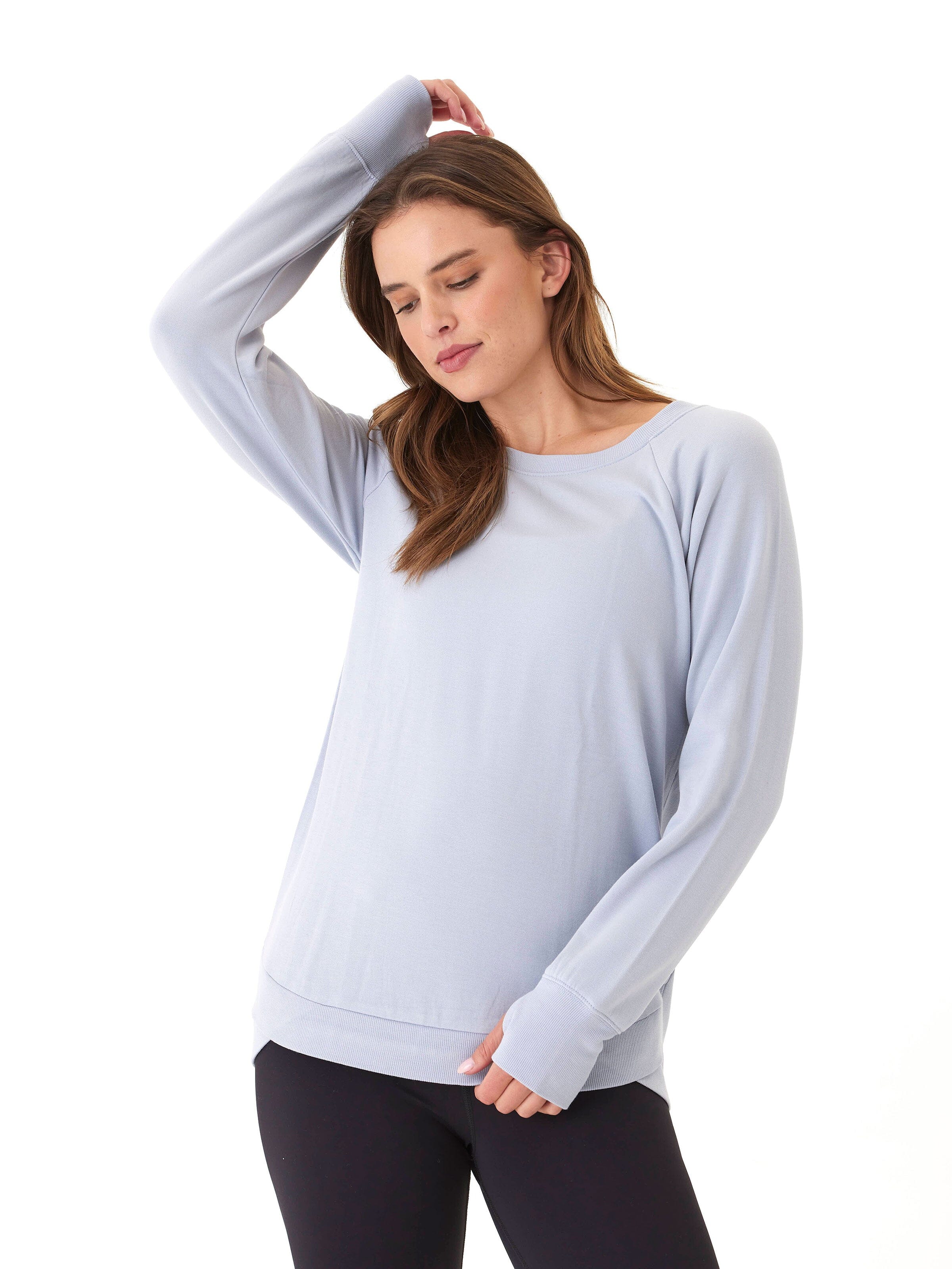 Light blue Feather Fleece tunic with tulip hem and relaxed fit, worn by a woman.