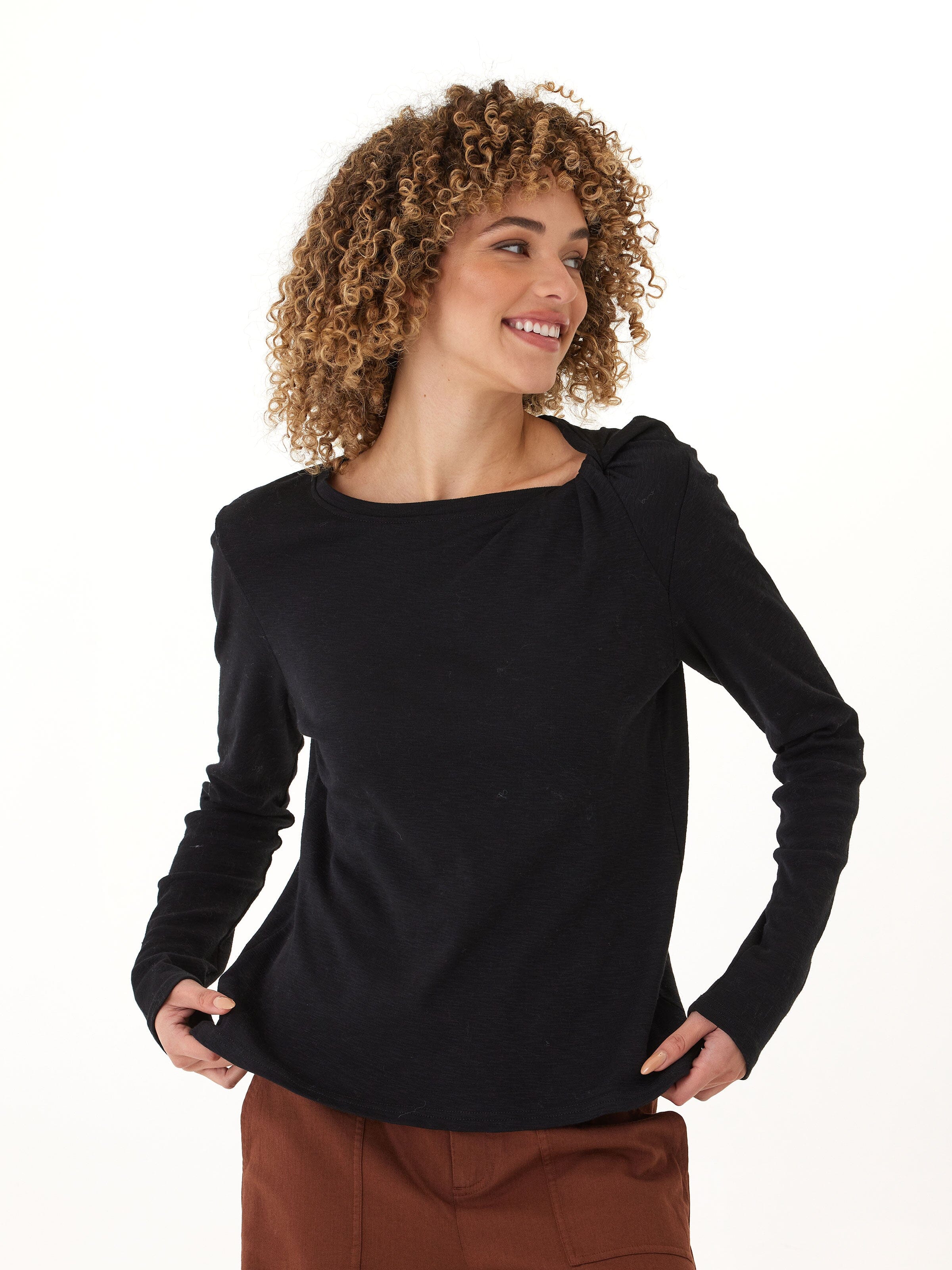 Close up of black long sleeve top showing textured slub jersey fabric and twisted shoulder detail.