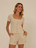 Close up of Jamila smocked jersey short sleeve top featuring square neckline and natural button details