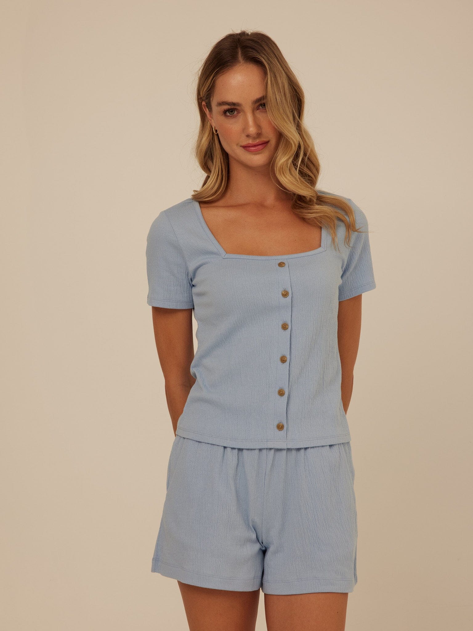 Close-up of the Jamila Smocked Jersey Short Sleeve top featuring a square neckline and button details.