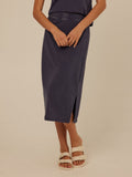 Model wearing Adella Mineral Wash Eco Jersey Midi Skirt with side slit and elastic waistband