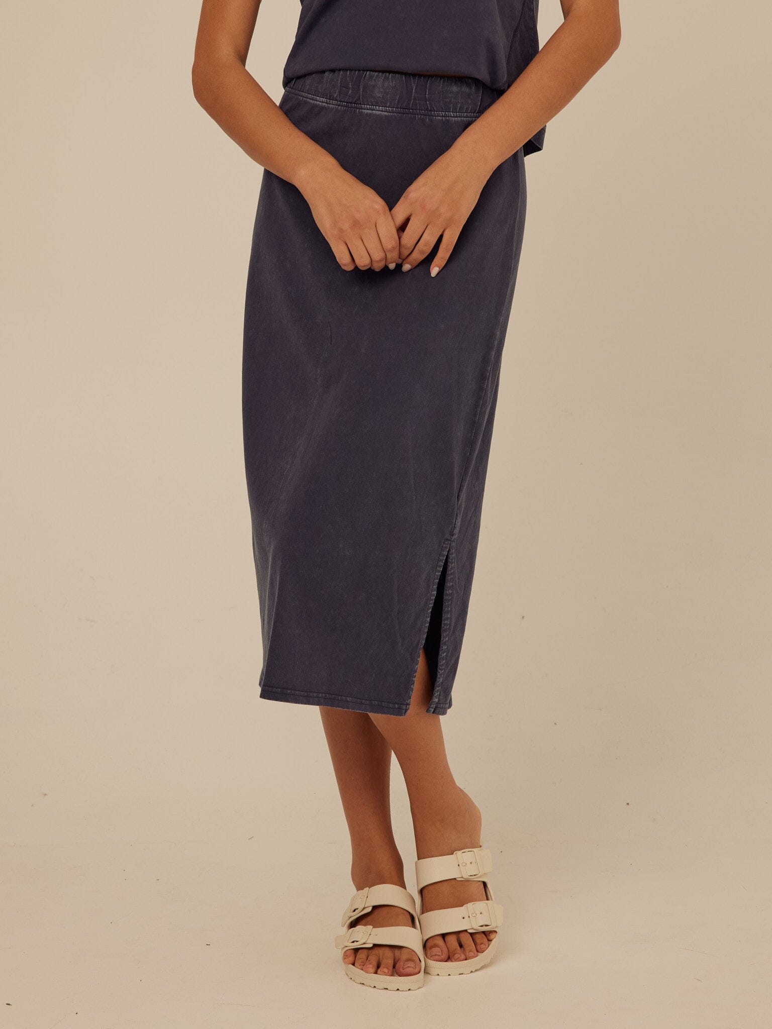 Model wearing Adella Mineral Wash Eco Jersey Midi Skirt with side slit and elastic waistband