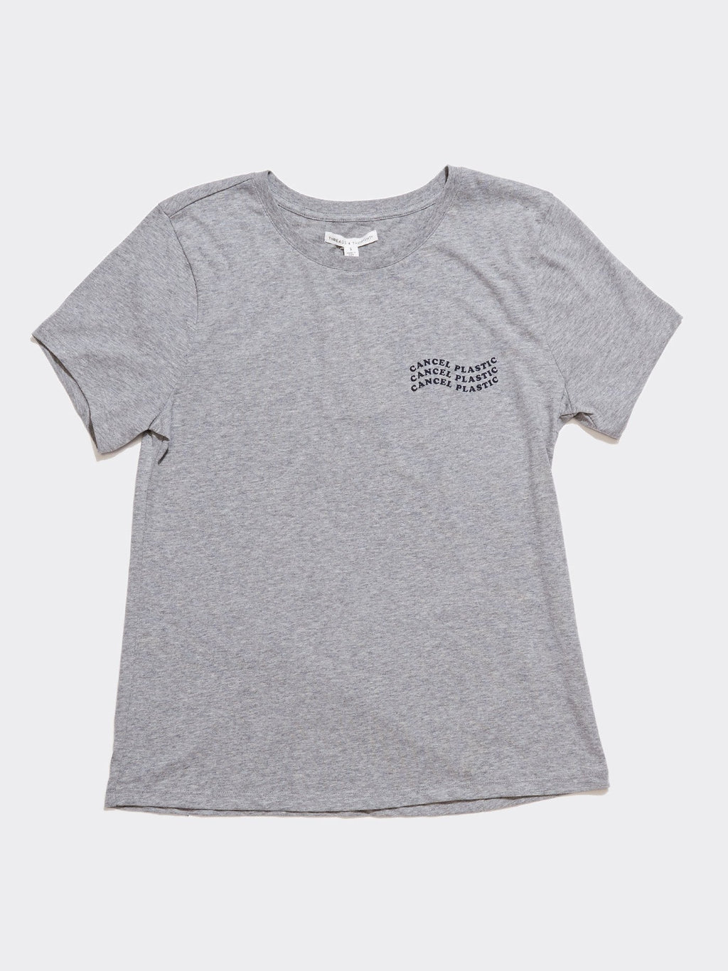 Women wearing a grey organic cotton Wavy Cancel Plastic graphic t-shirt in a casual minimalist style.
