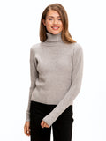 Woman wearing a soft light grey Toki rib knit turtleneck sweater with a loose tall neck