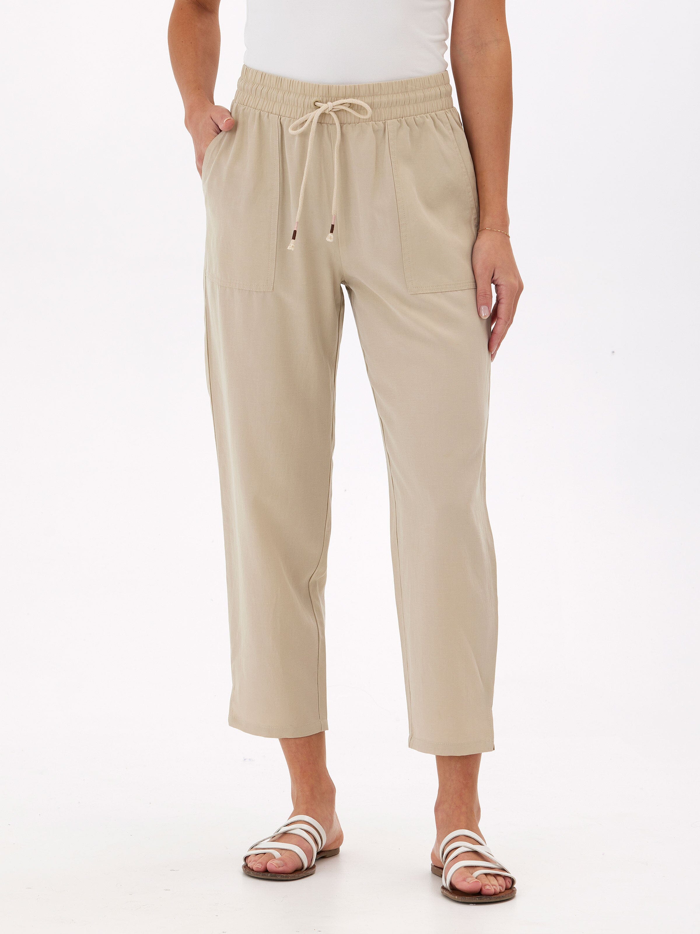 Woman wearing beige Winnie Breezy linen blend cropped pants with a relaxed, tapered fit.