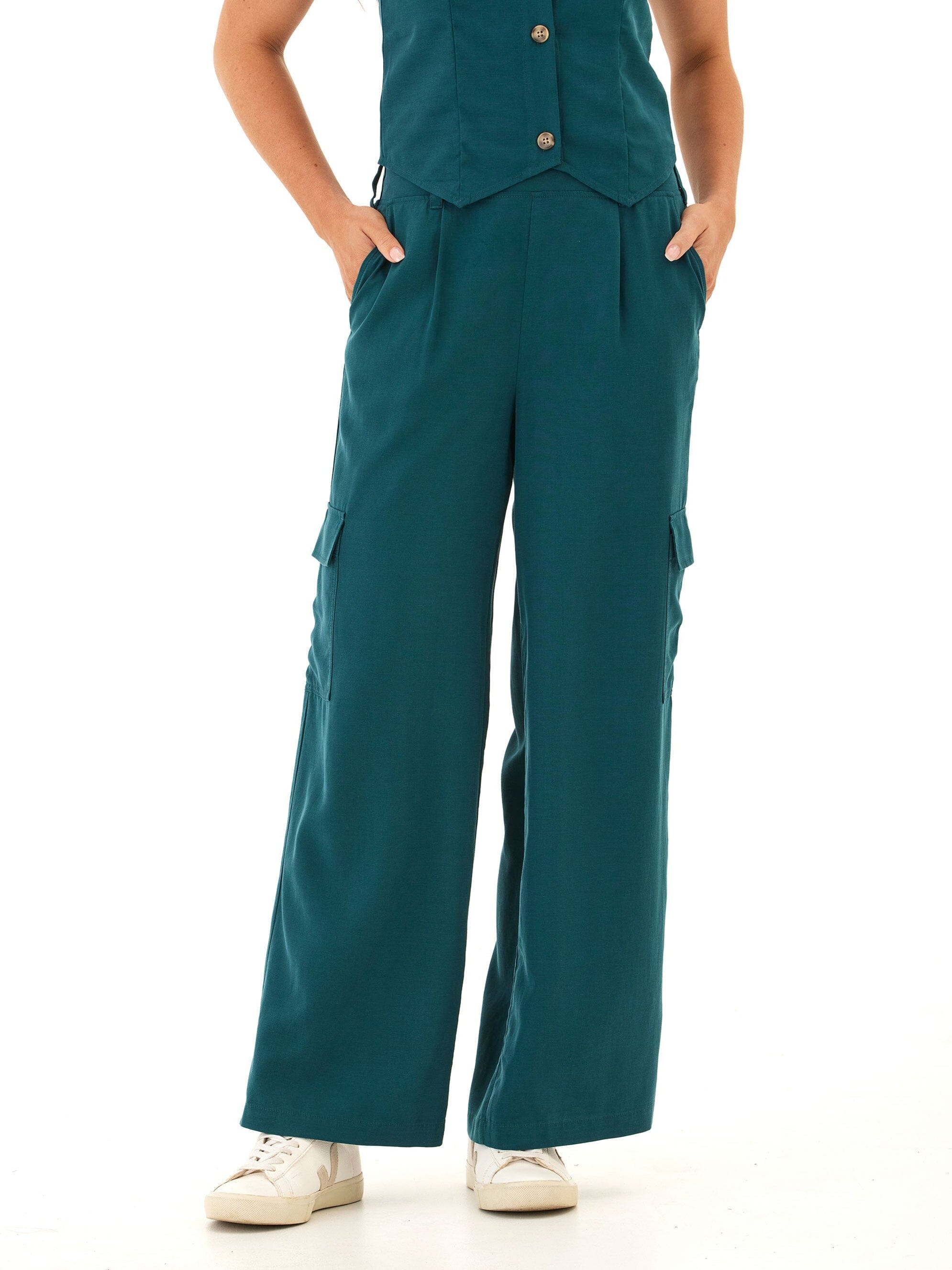 A woman wearing breezy teal wide-leg linen cargo pants with patch pockets in a minimalist style.