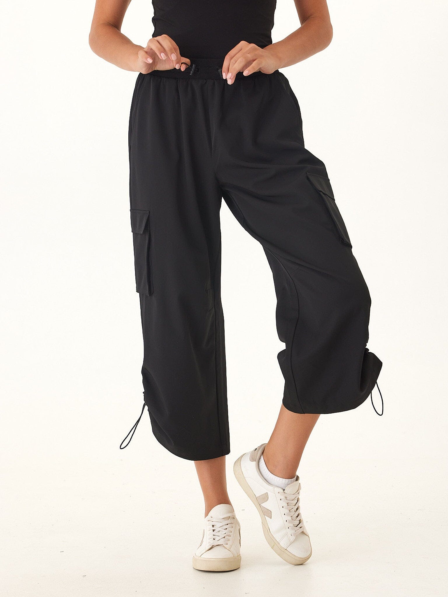 Woman wearing black Sanya Performance 2-Way Stretch Barrel Pants with adjustable drawcord hems.