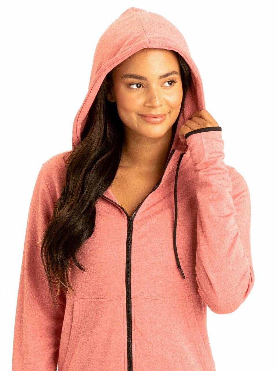 Woman wearing the Sybil FeatherLoop fleece slim fit athletic hoodie in coral