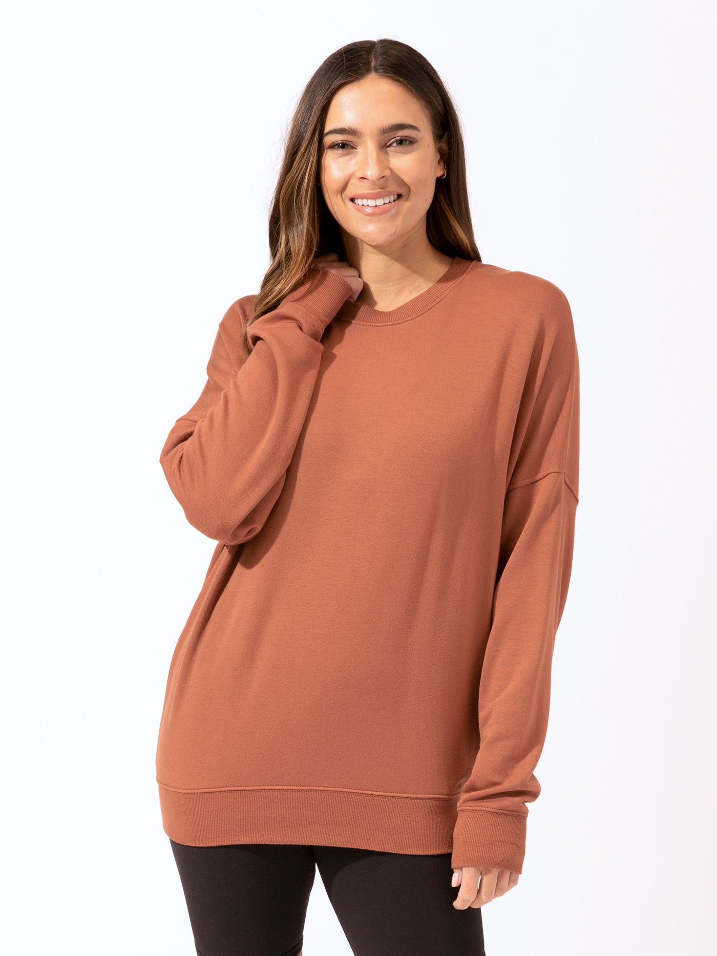 Woman wearing a relaxed-fit Core Feather Fleece Sweatshirt in rust color