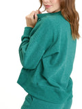 Woman wearing a solid green Naia Triblend Fleece Pullover in a minimalist loungewear style