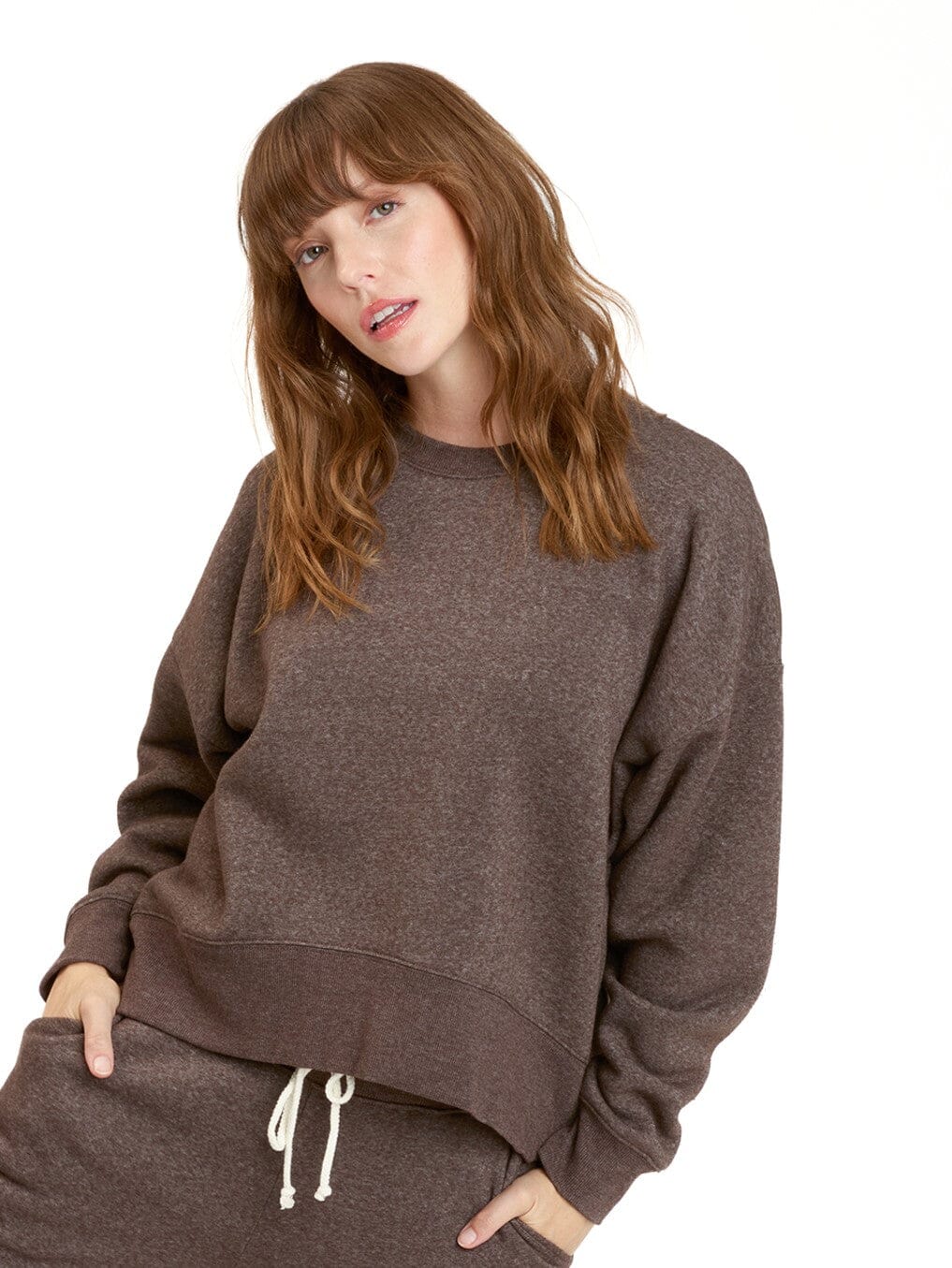 Woman wearing an oversized brown triblend fleece crop pullover.
