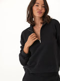 Woman wearing a black Constance triblend fleece half zip pullover.
