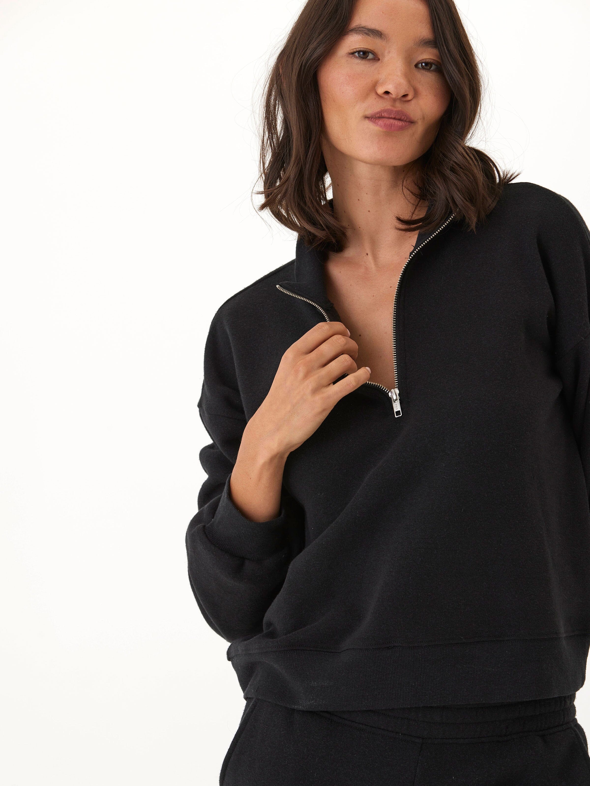 Woman wearing a black Constance triblend fleece half zip pullover.