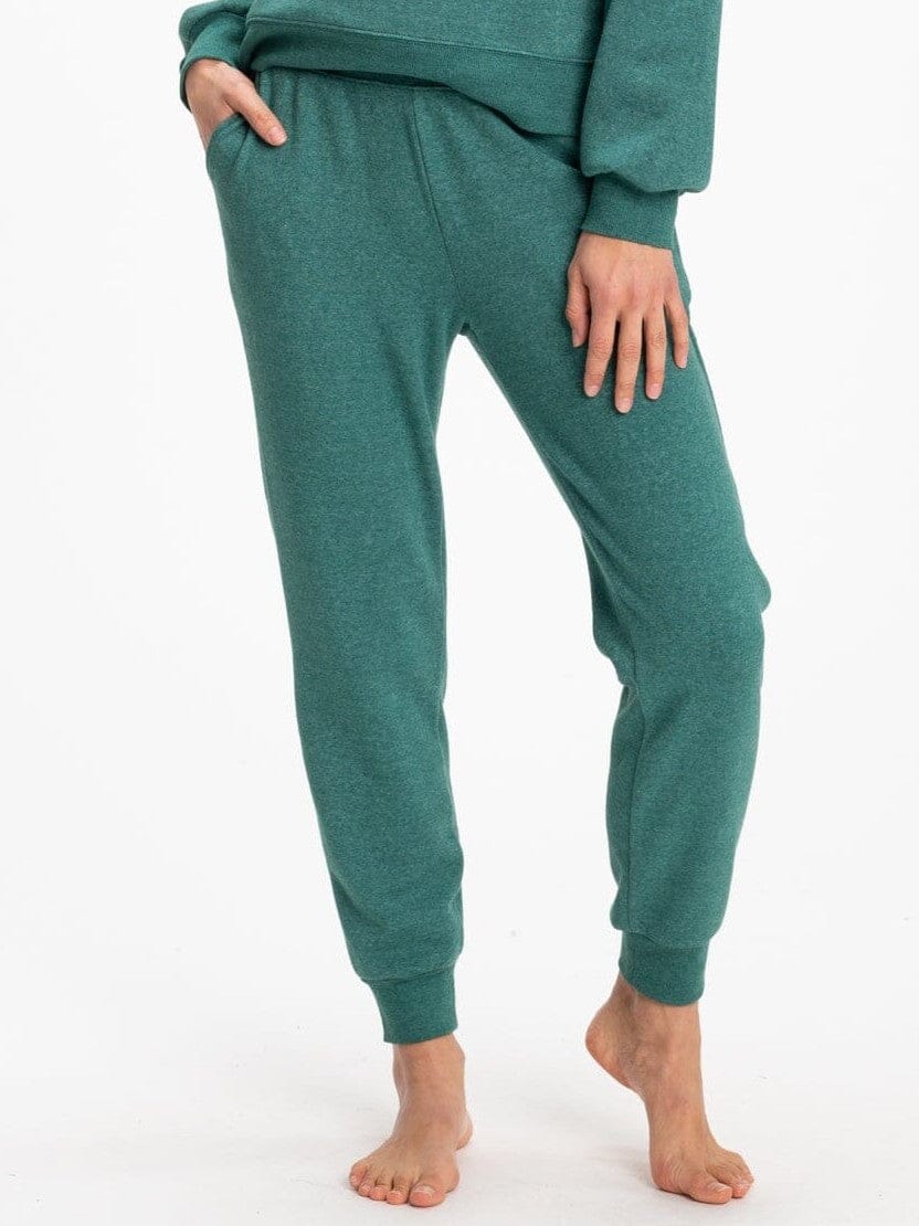 Woman wearing slim fit forest green knit joggers with drawstring waist and ankle-length tapered silhouette