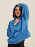Woman wearing a solid blue Marcellina triblend fleece pullover hoodie with an athletic fit