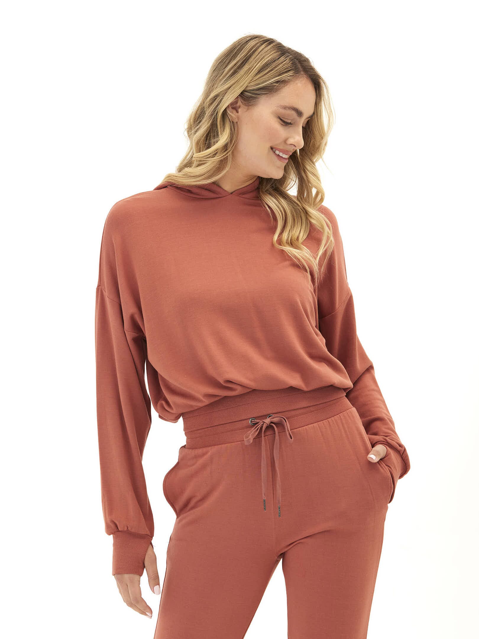 Rust colored feather fleece pullover hoodie with thumbholes and elastic waist.