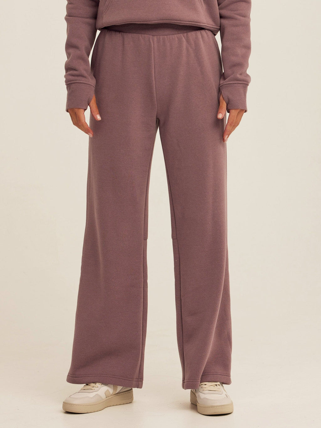 Woman wearing high-rise dusty-mauve triblend fleece flare pants in a relaxed athleisure style