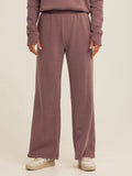 Woman wearing high-rise dusty-mauve triblend fleece flare pants in a relaxed athleisure style