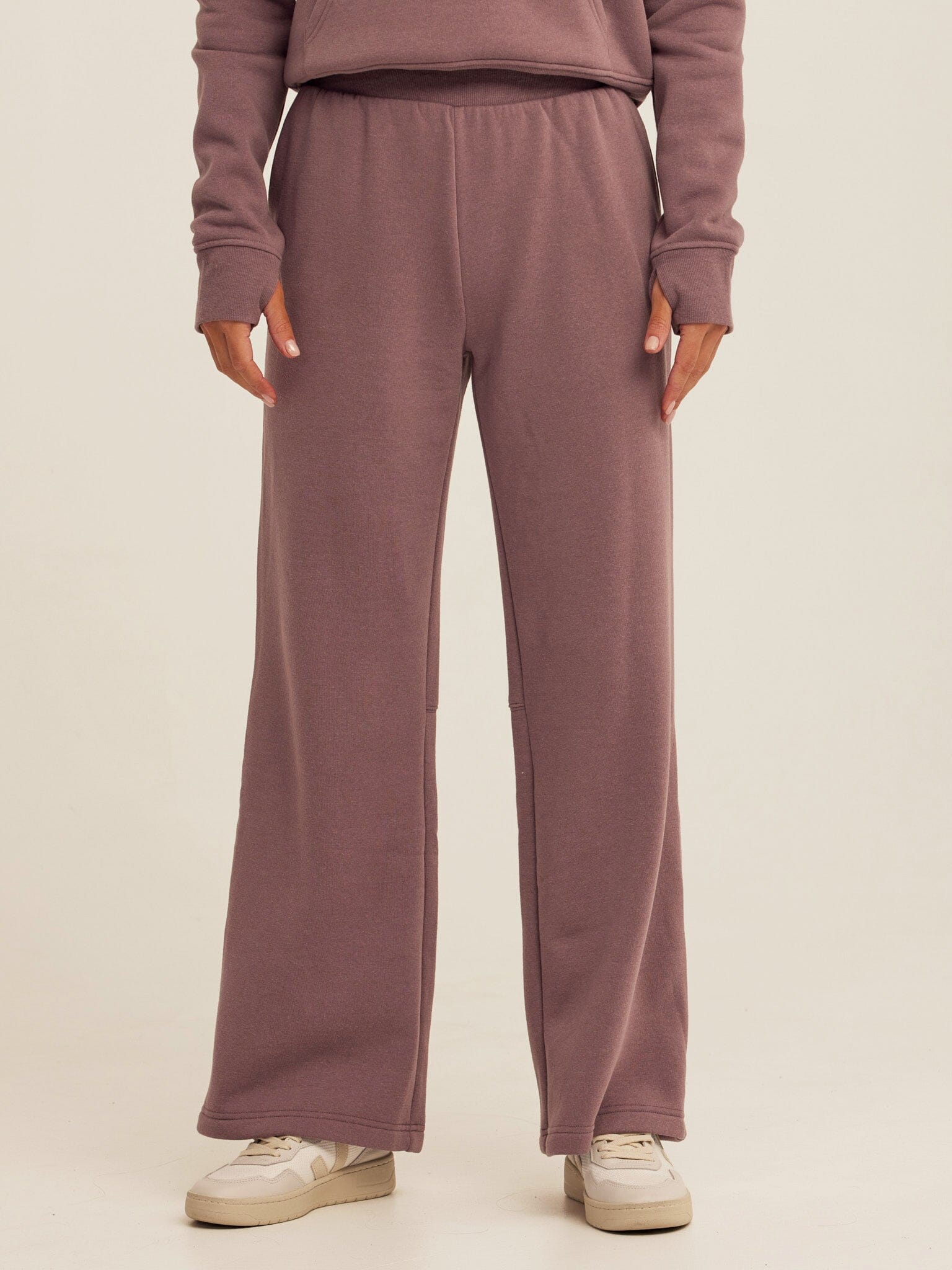 Woman wearing high-rise dusty-mauve triblend fleece flare pants in a relaxed athleisure style