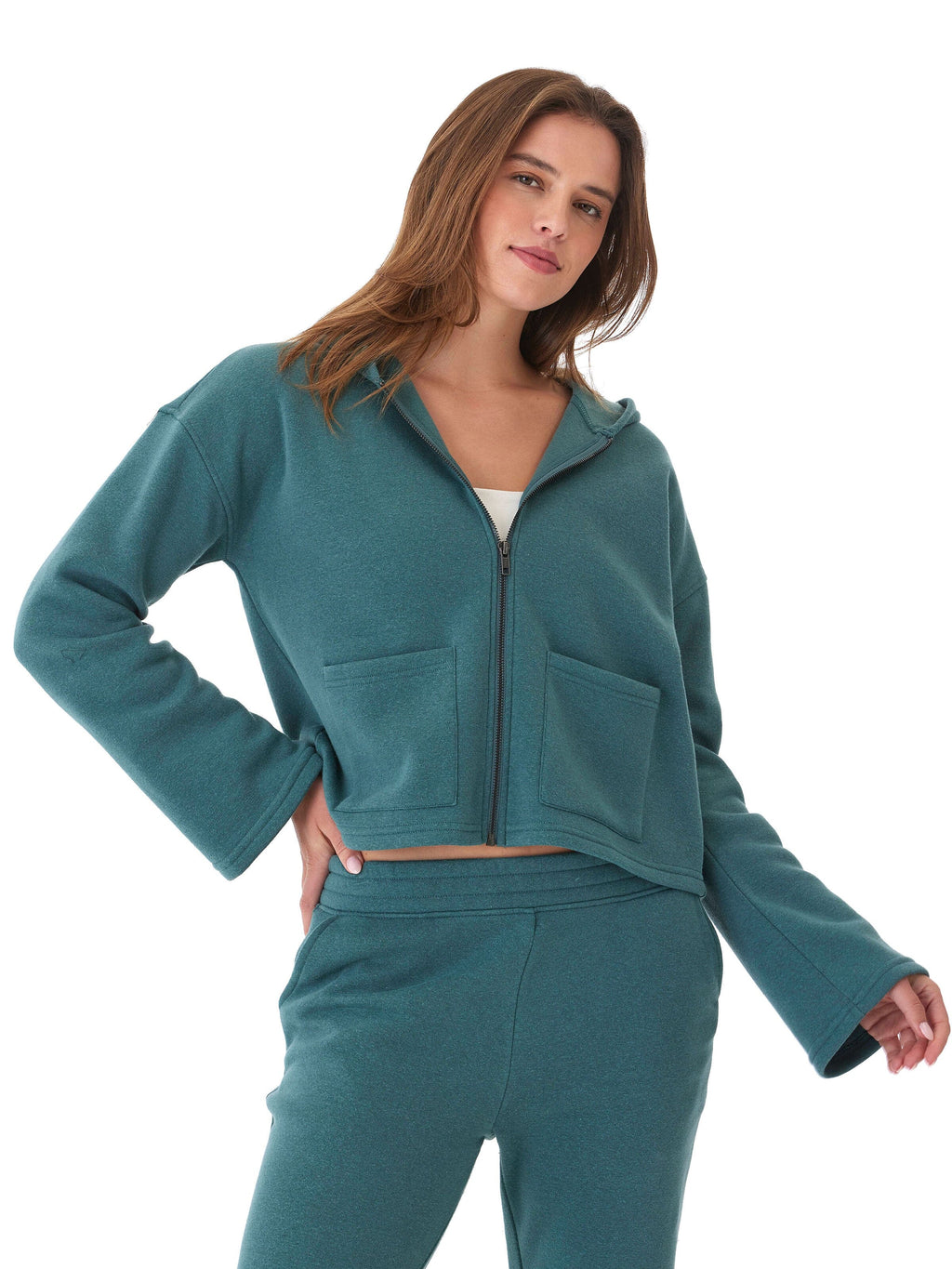 Woman wearing a comfortable teal triblend fleece hoodie with wide sleeves and front pockets