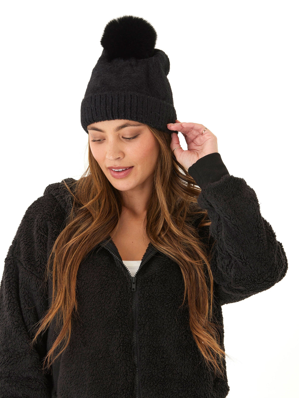 A stylish black fuzzy knit beanie with a pom-pom detail on top