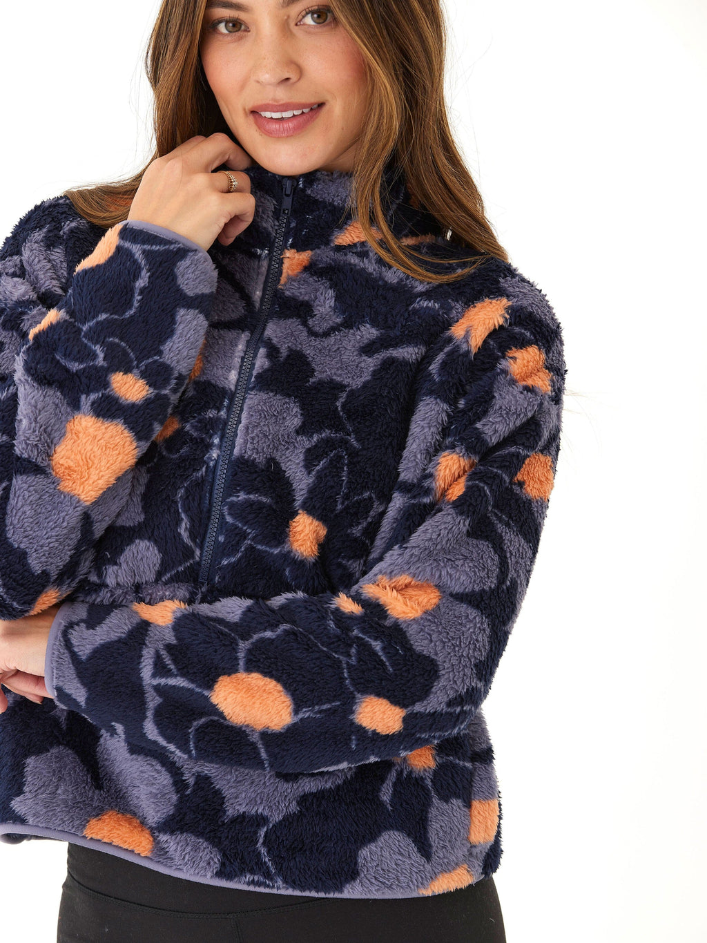 A woman wearing a cozy abstract floral print sherpa 1/2-zip pullover in navy blue