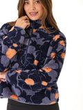 A woman wearing a cozy abstract floral print sherpa 1/2-zip pullover in navy blue