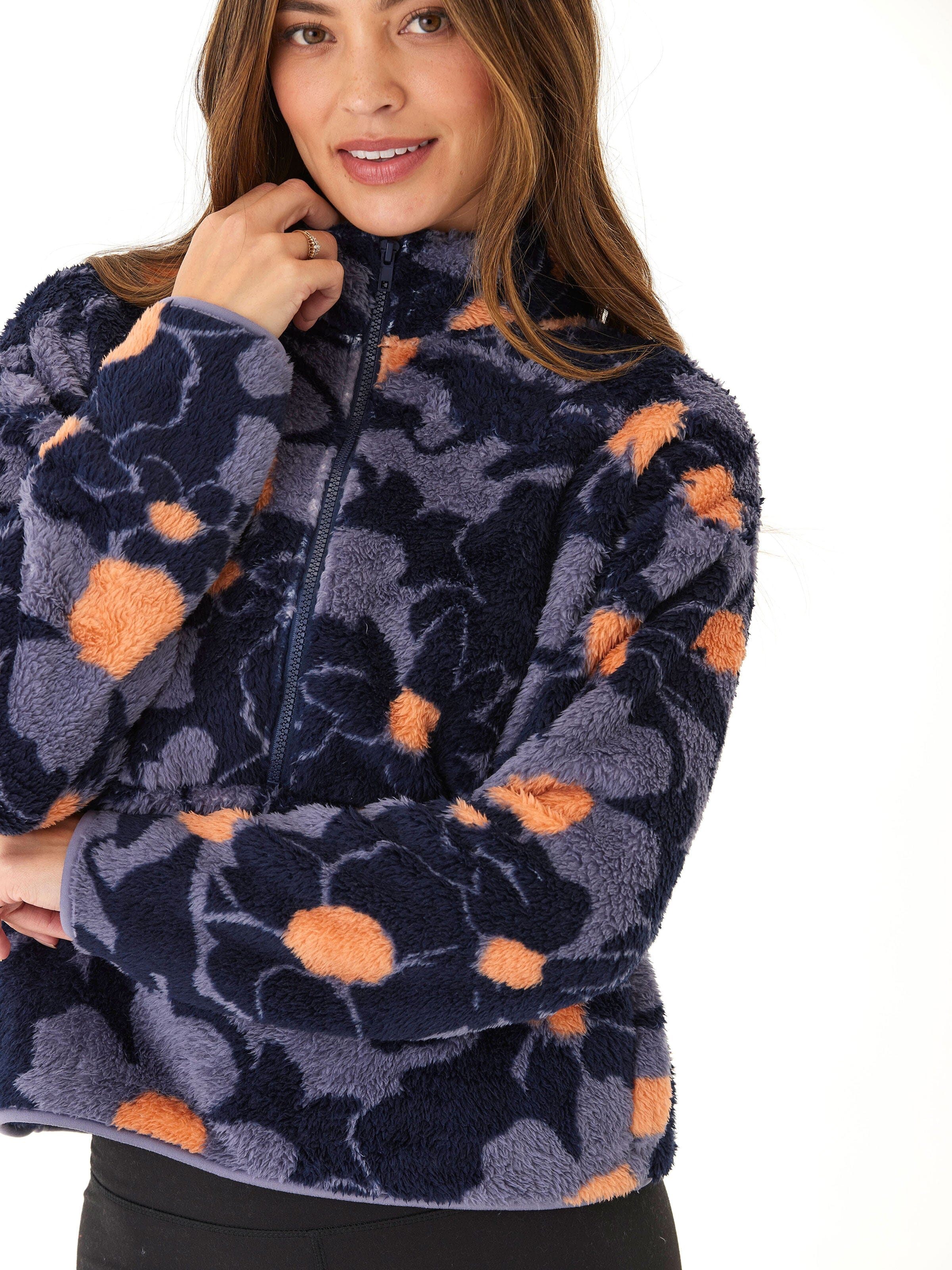 A woman wearing a cozy abstract floral print sherpa 1/2-zip pullover in navy blue