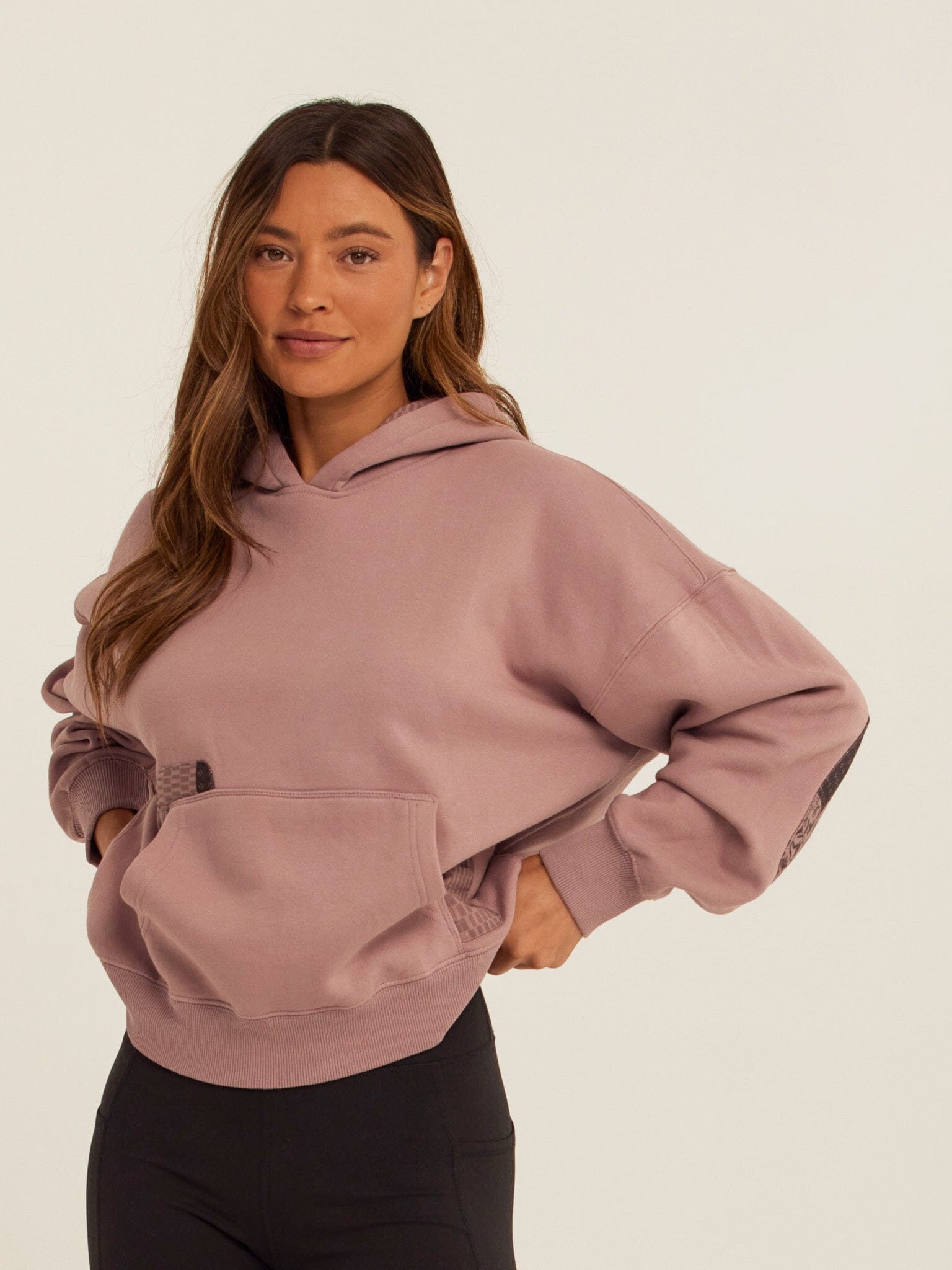 Oversized dusty-rose vintage wash hoodie with dark-grey and black patchwork elbow details