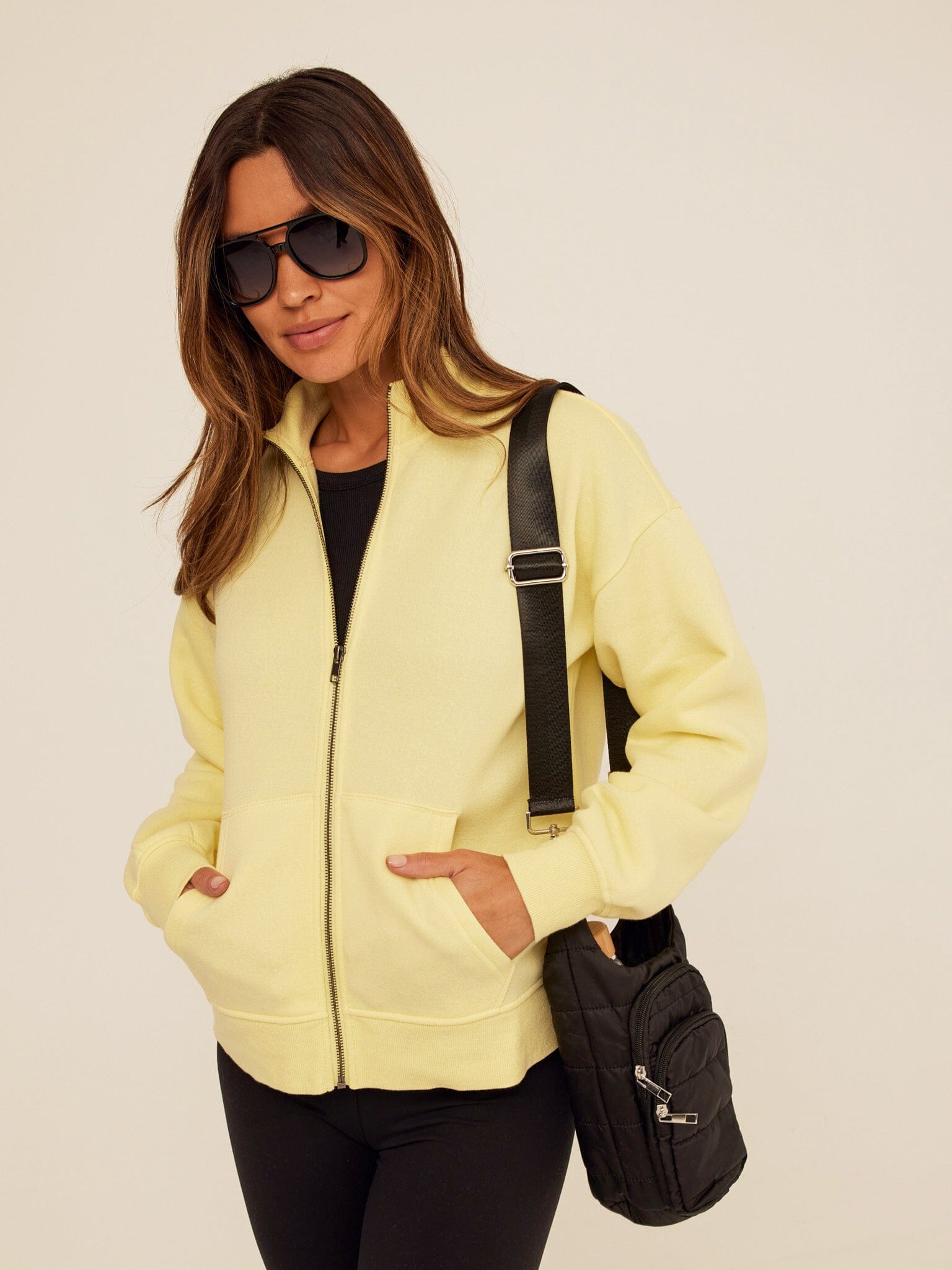 A pale yellow long-sleeve knit zip jacket with a stand collar, styled for a sporty-leisure look.
