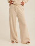 Women wearing beige Core Triblend Fleece Sweatpants in a relaxed minimalist loungewear style