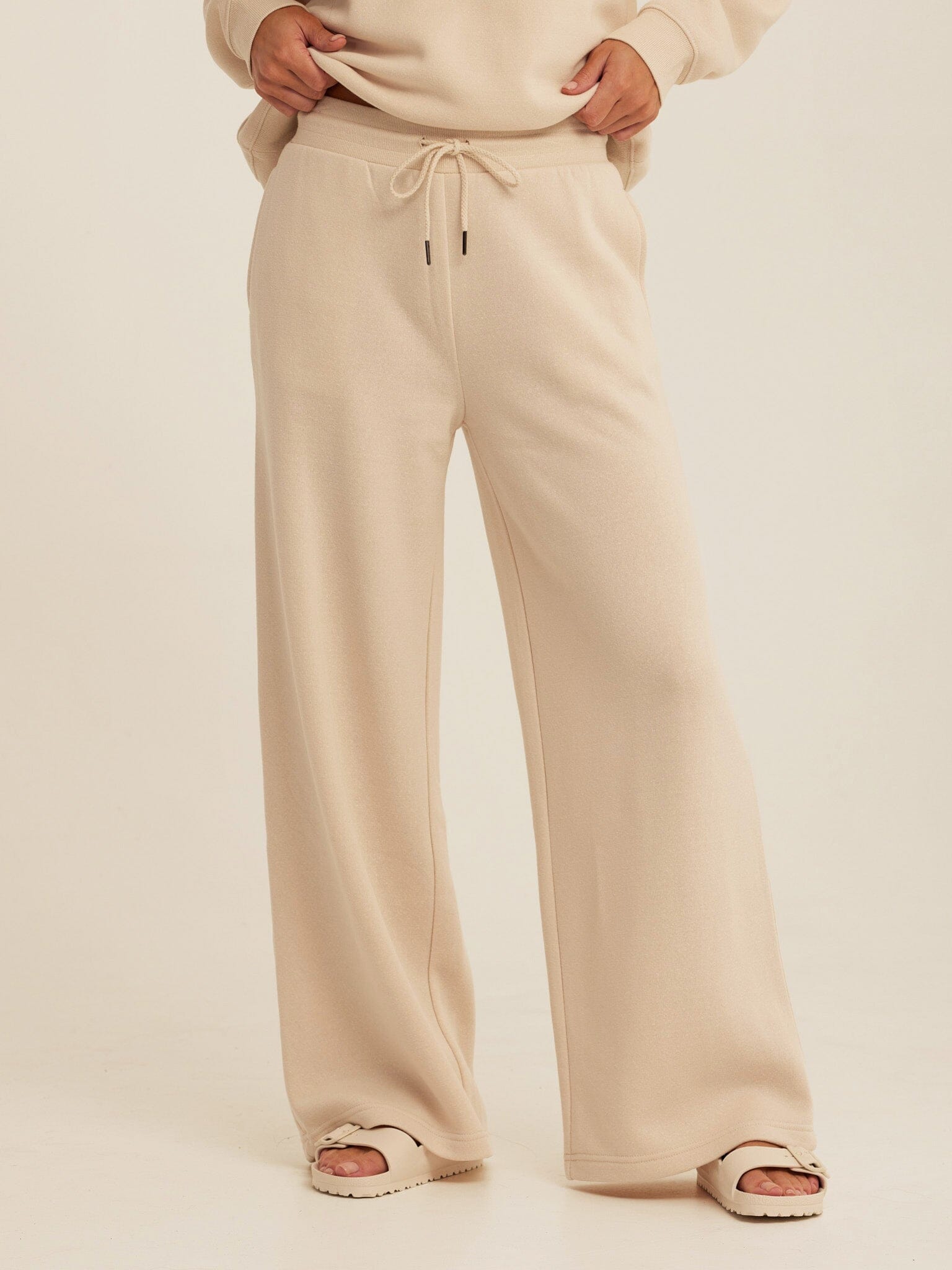 Women wearing beige Core Triblend Fleece Sweatpants in a relaxed minimalist loungewear style